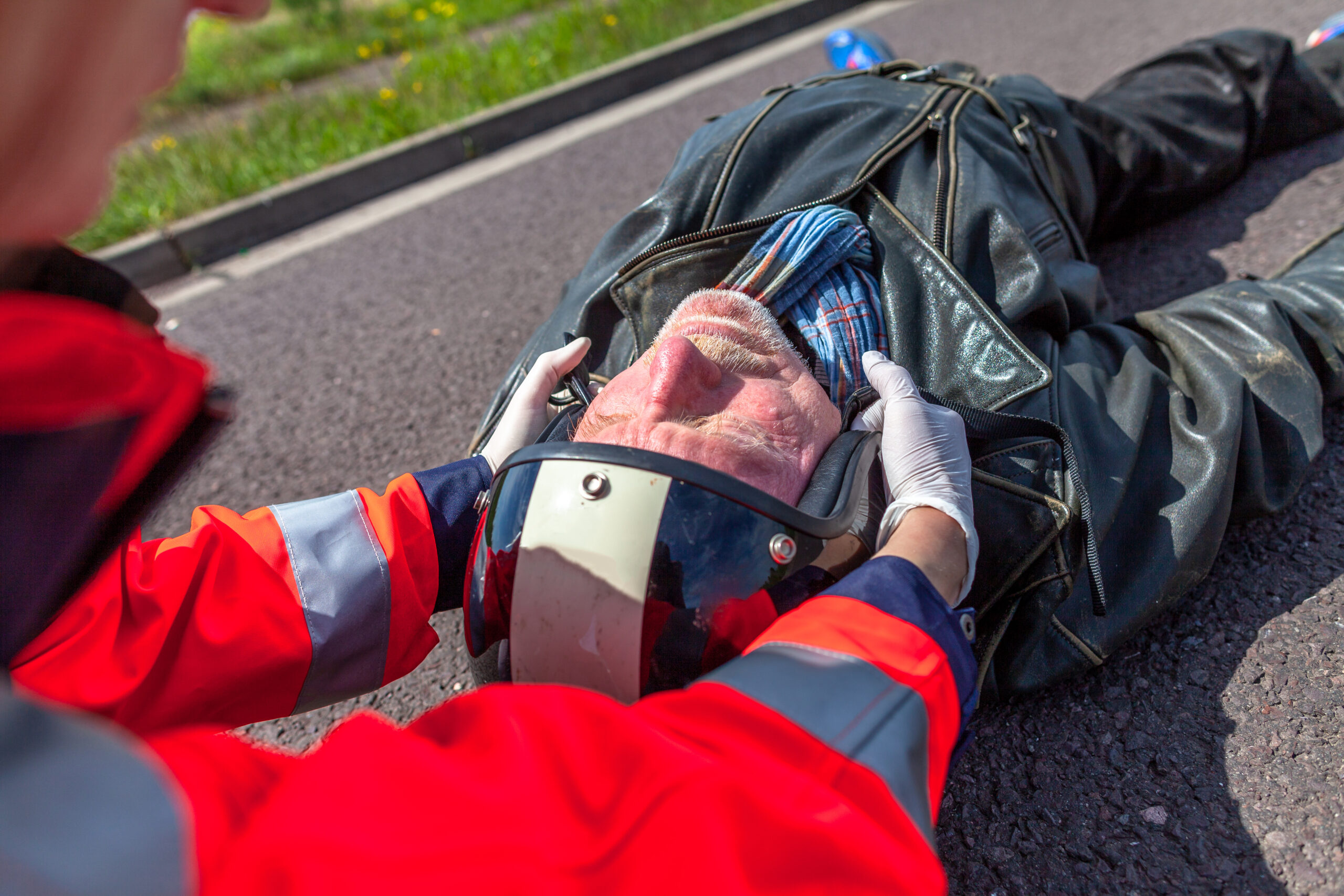 A paramedic removes the helmet off of an injured motorcycle rider